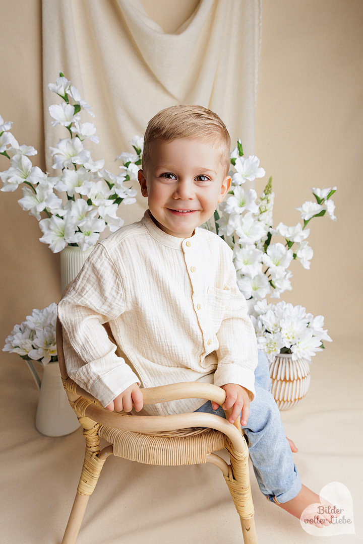 Kind auf Rattenstuhl im Fotostudio in Berlin bei Fotoshooting